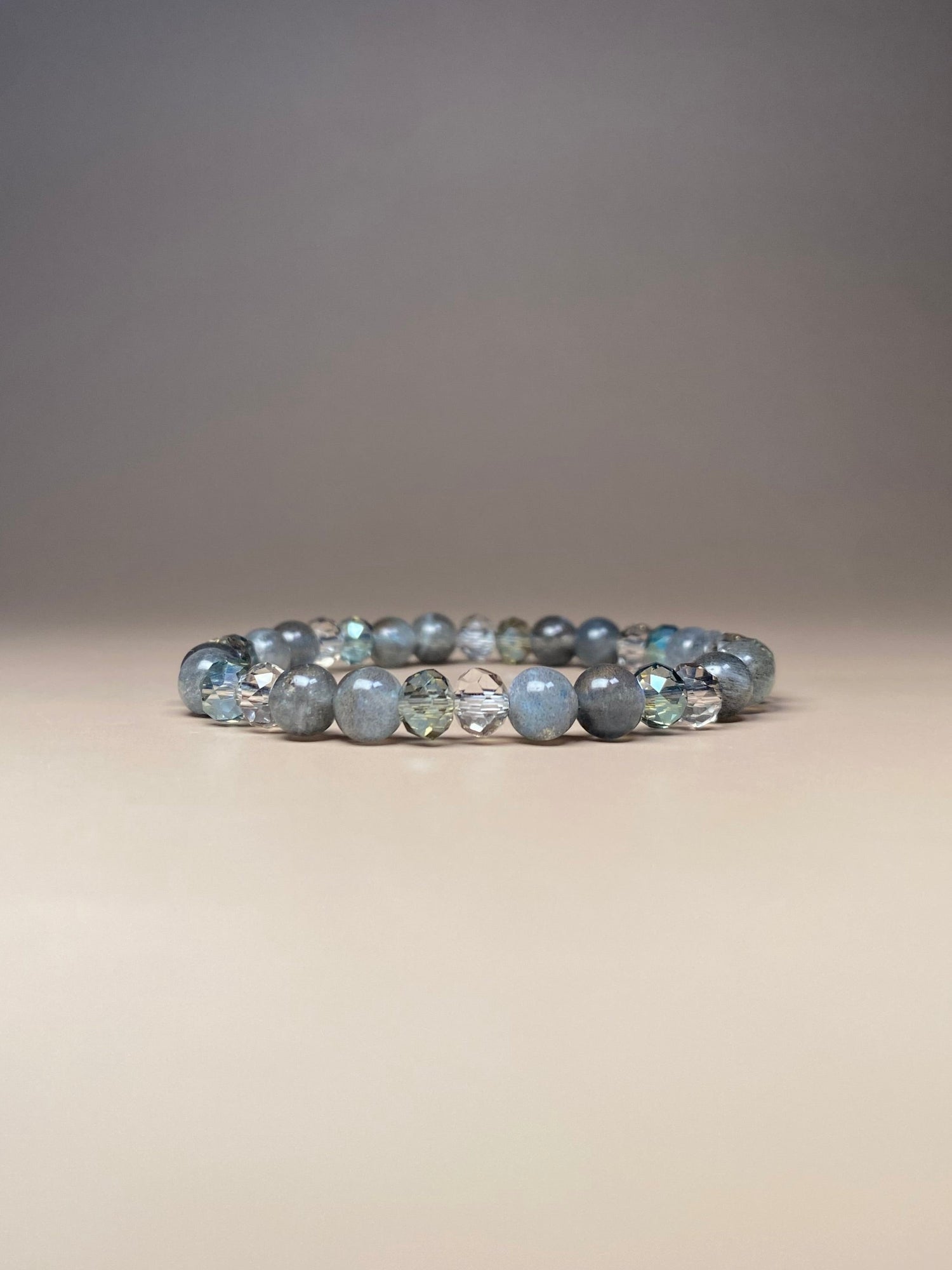 Close-up of the Abby 6mm Labradorite Bracelet featuring shimmering A+ labradorite beads in the center, showcasing their iridescent sparkle. The bracelet's delicate, hand-crafted design highlights the natural beauty of the stones, catching the light at every angle.