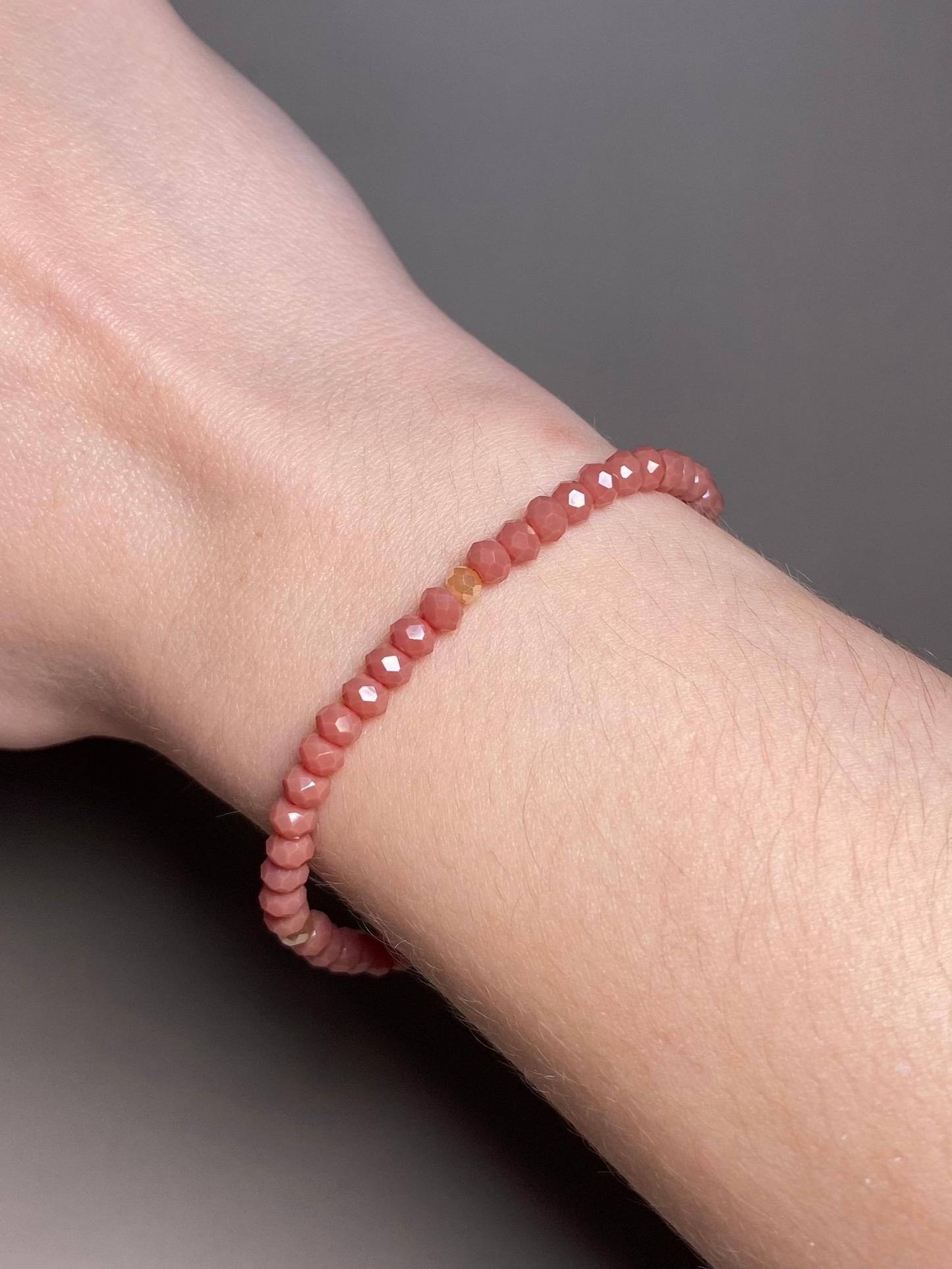 The Alice Dark Dusty Rose 5mm Bracelet adorning a wrist, highlighting the soft tones of dark dusty rose and cream beads, perfect for any occasion.