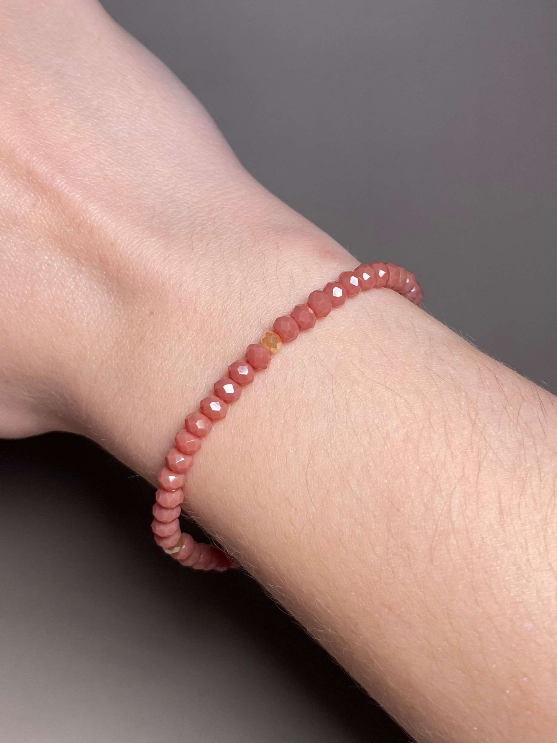 The Alice Dark Dusty Rose 5mm Bracelet adorning a wrist, highlighting the soft tones of dark dusty rose and cream beads, perfect for any occasion.