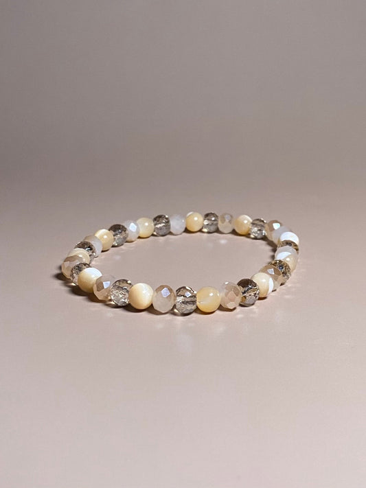 Stella 6mm Mother of Pearl Sparkle Bracelet featuring shimmering 6mm mother of pearl beads, complemented by two variations of shiny cream opaque and translucent 6mm beads, elegantly arranged in the center and sparkling beautifully.